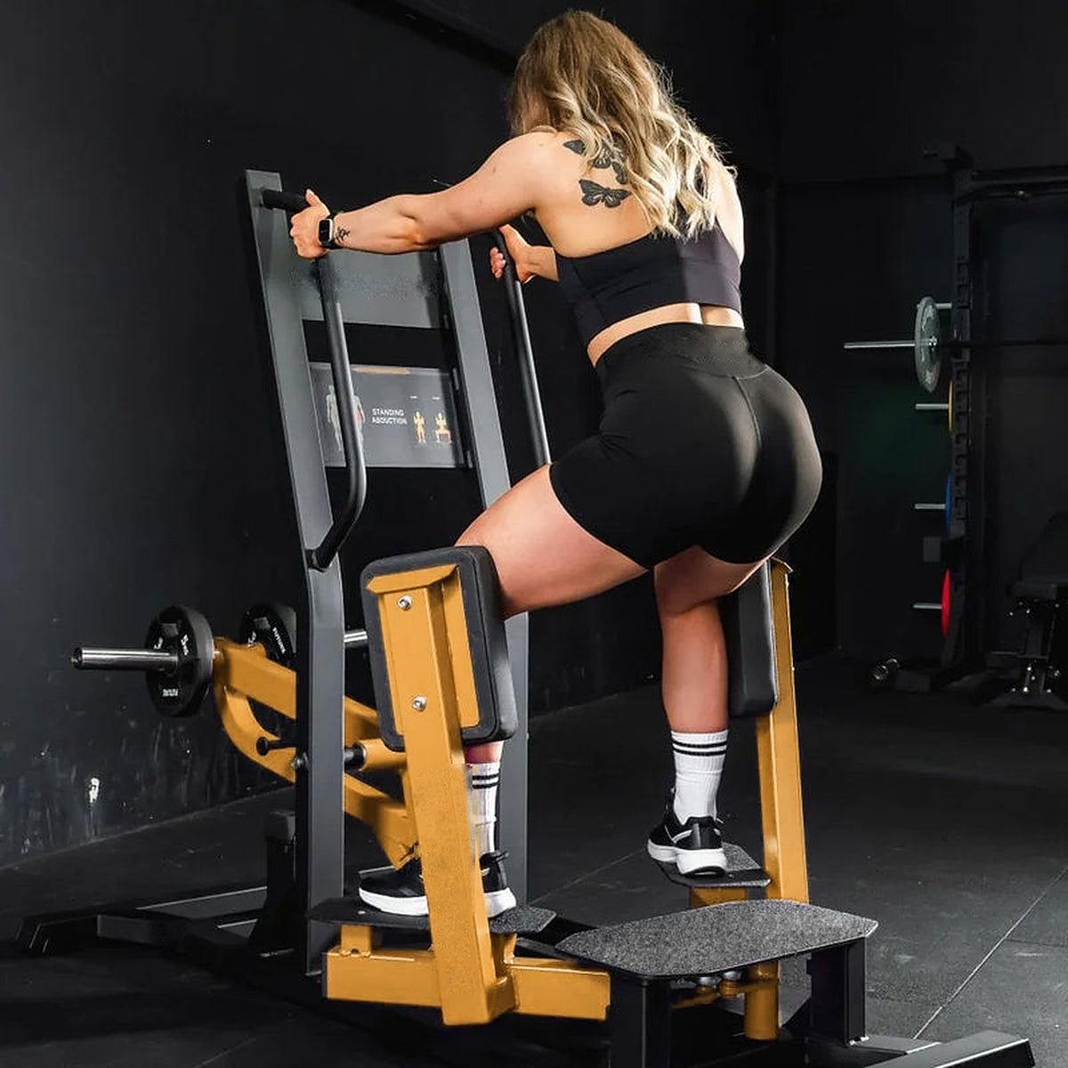 Athlète en abduction de hanche debout sur la machine UltraFitness jaune