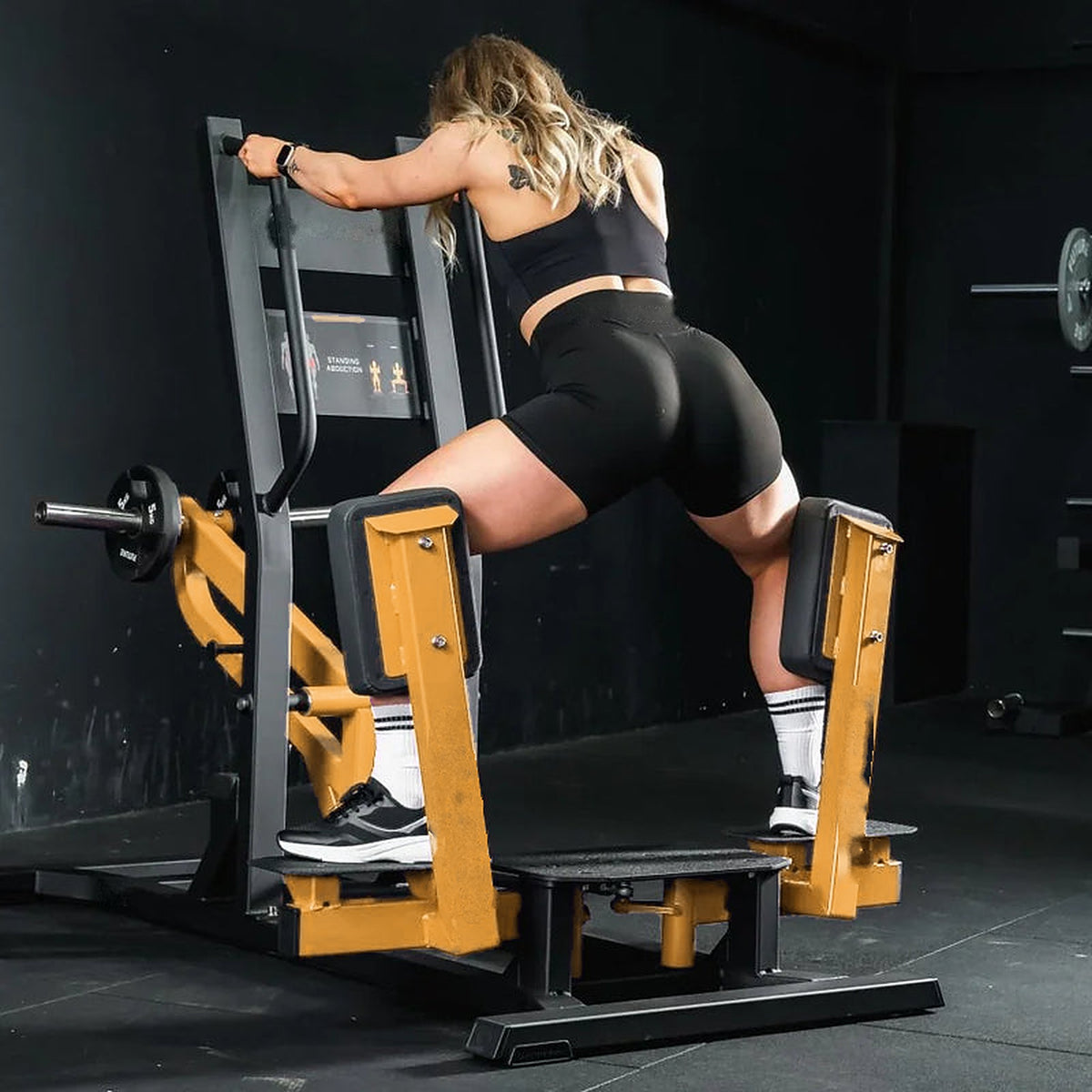 Athlète en position d'écart maximal sur la machine abduction debout UltraFitness